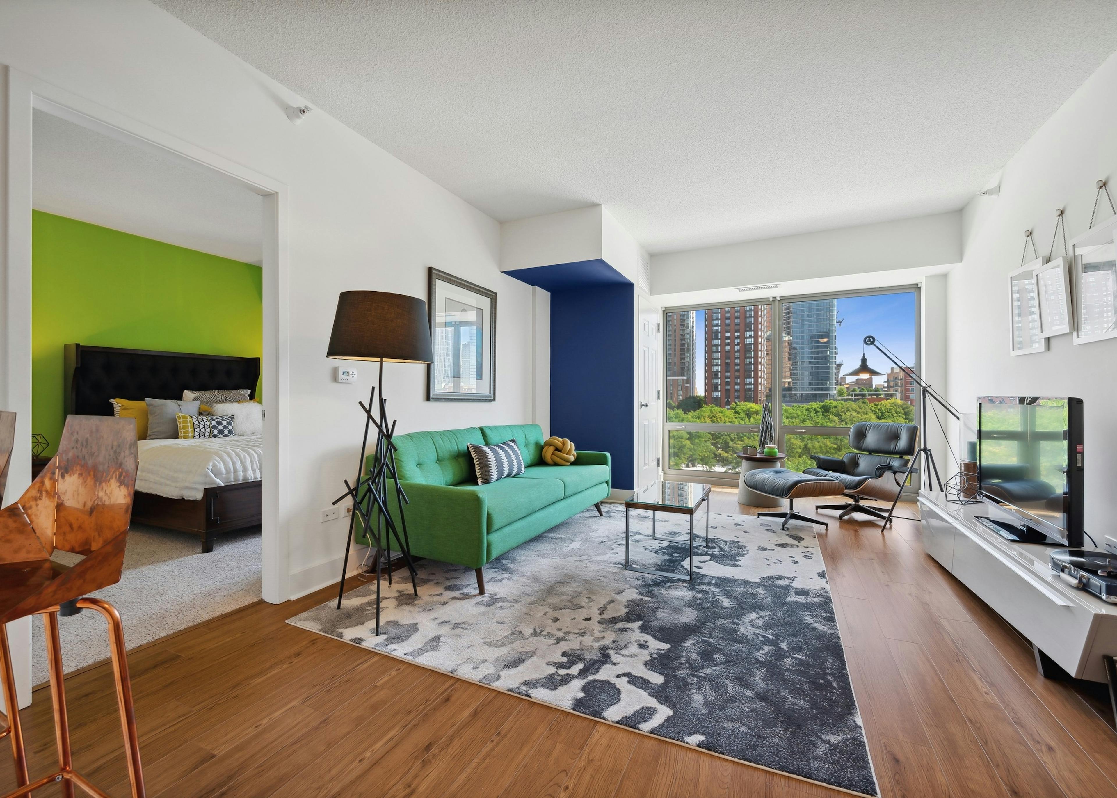 Interior view of an AMLI 900 living room with cream colored walls paired with light wood flooring and vintage decor