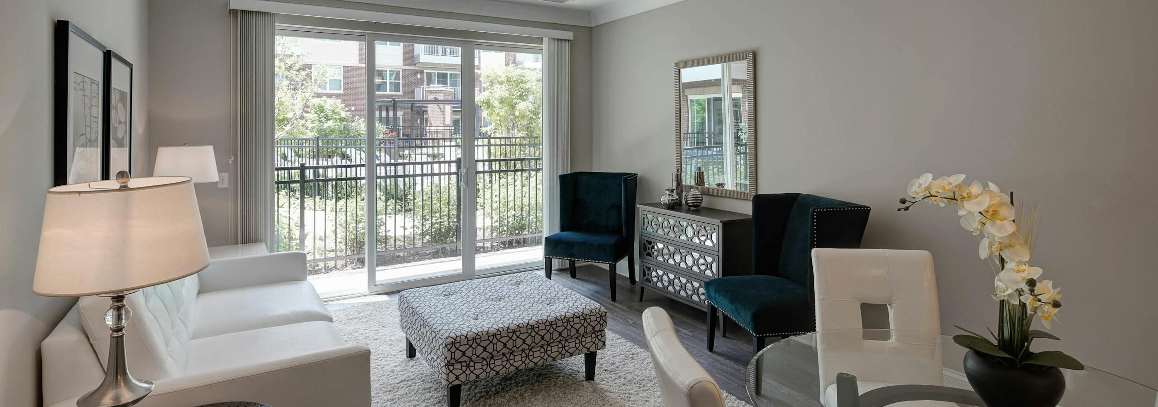 Interior of AMLI Deerfield apartment dining room and living room with private balcony overlooking courtyard pool view 