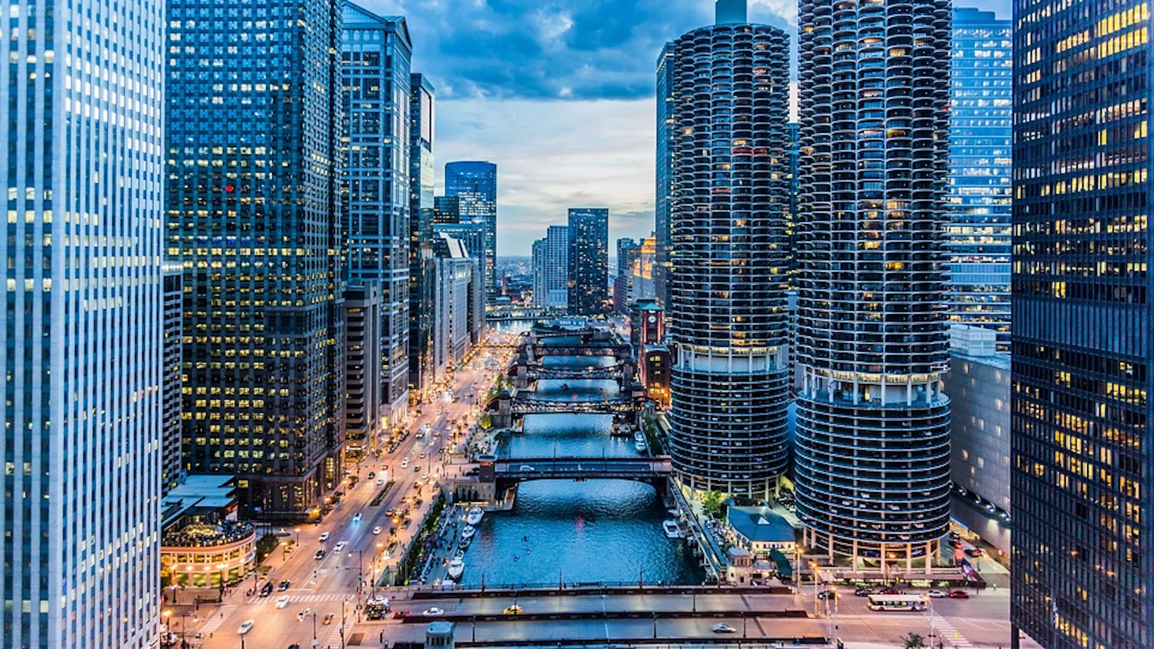 An overhead shot of the Chicago River running  through the center and all the buildings towering around it