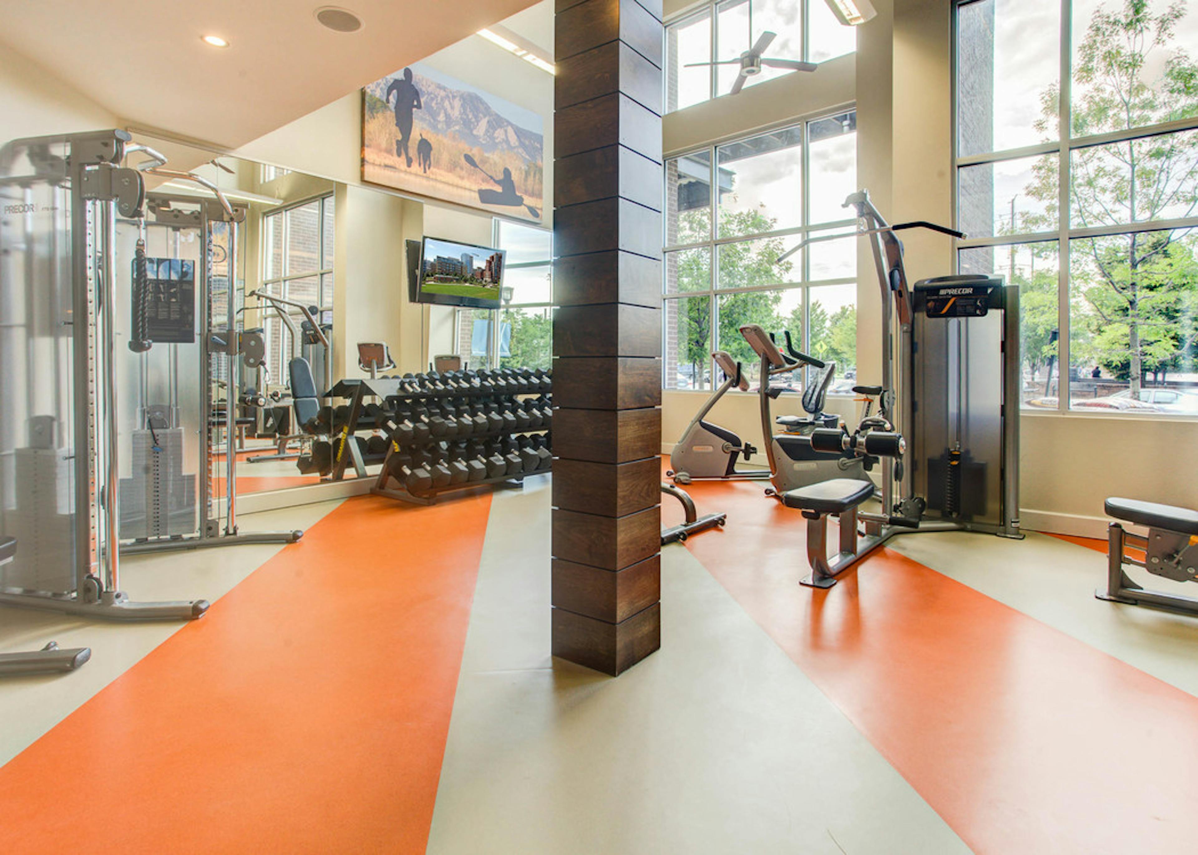 Interior of the fitness center at AMLI Riverfront Park apartments with medicine balls and a variety of workout equipment 