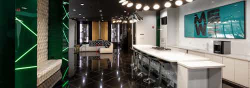 AMLI Uptown expansive entertainment lounge with a resident kitchen equipped with a gas stove top and island stool seating