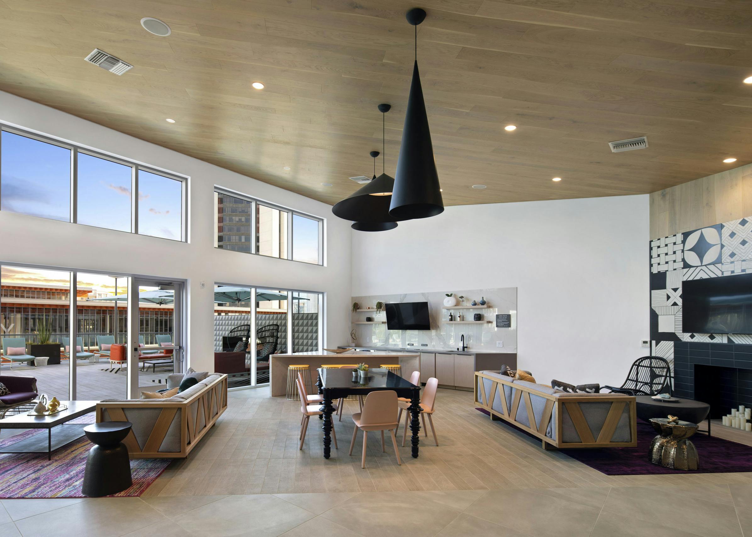 Interior view of clubhouse at AMLI Park Broadway with black table and six pink chairs at center and various seating