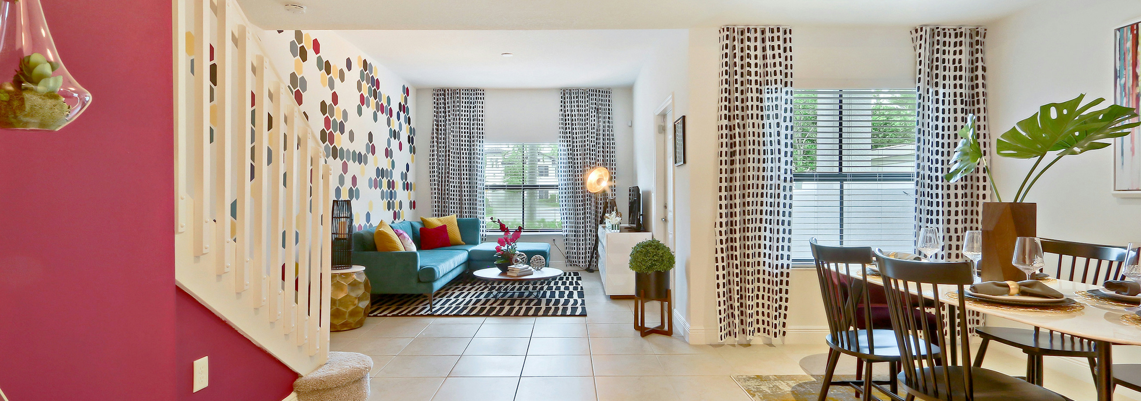 Interior view of AMLI Toscana Place townhome dining area table and chairs, with a window view and peek into the living room 