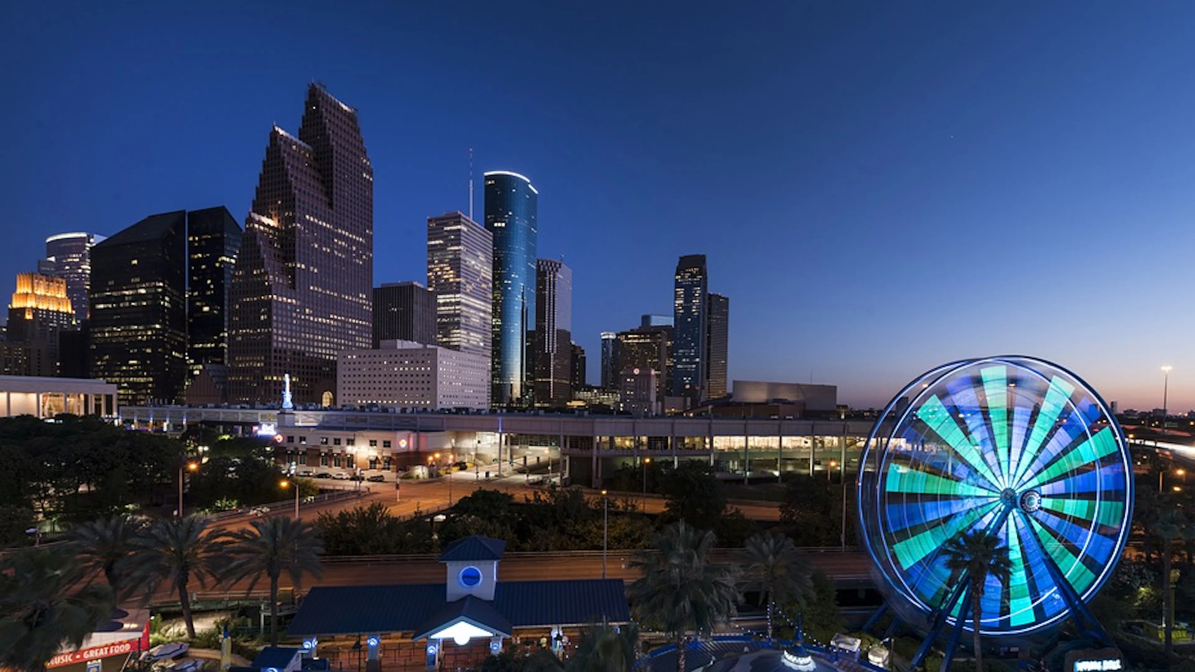 Downtown Houston at night with a lit Ferris wheel spinning in the foreground
