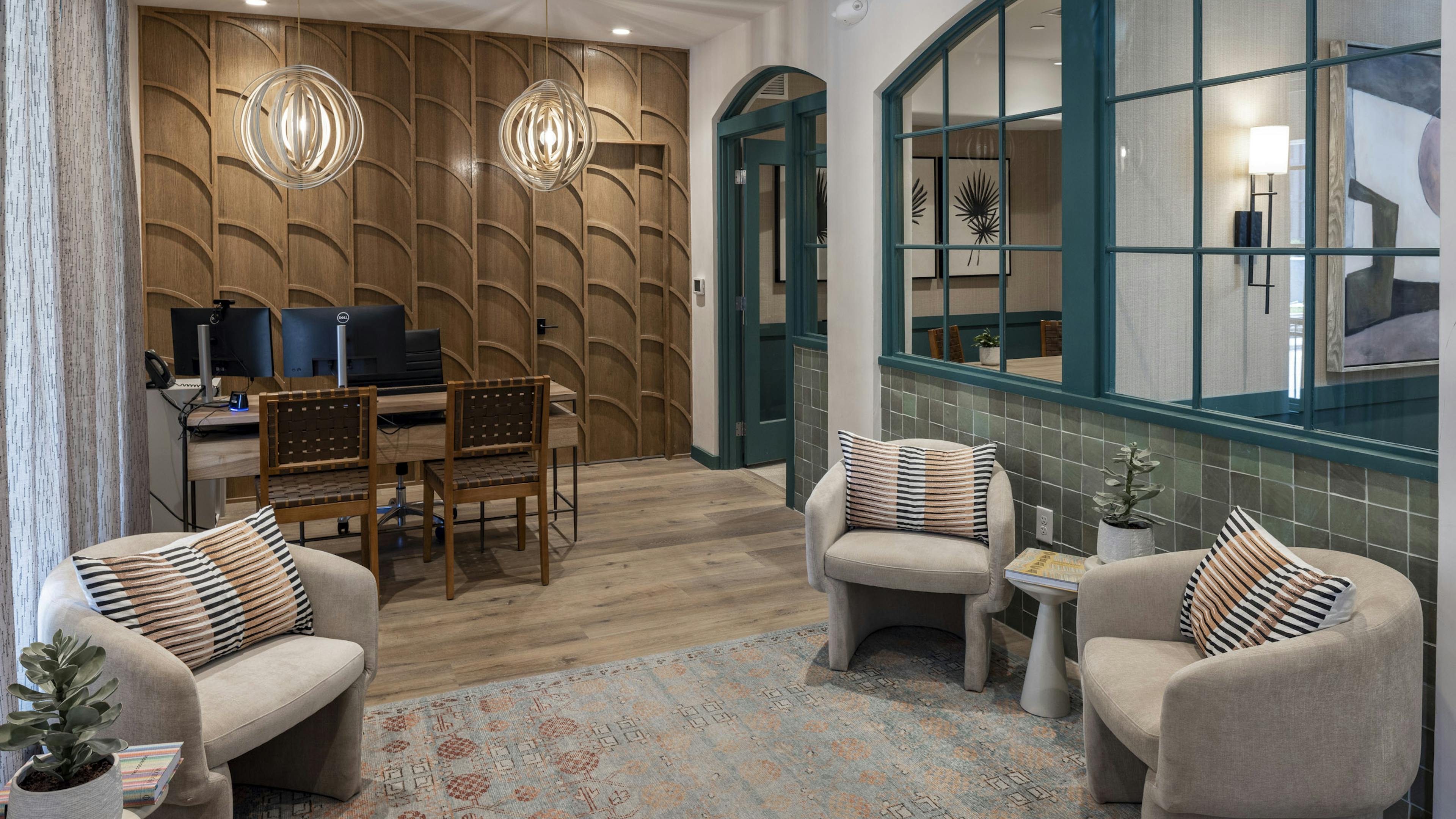 AMLI 300 apartments leasing office with wood textured wall and a desk with 2 chairs and upholstered chairs on an area rug