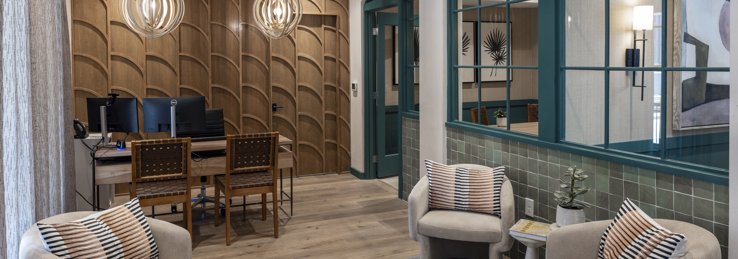 AMLI 300 apartments leasing office with wood textured wall and a desk with 2 chairs and upholstered chairs on an area rug