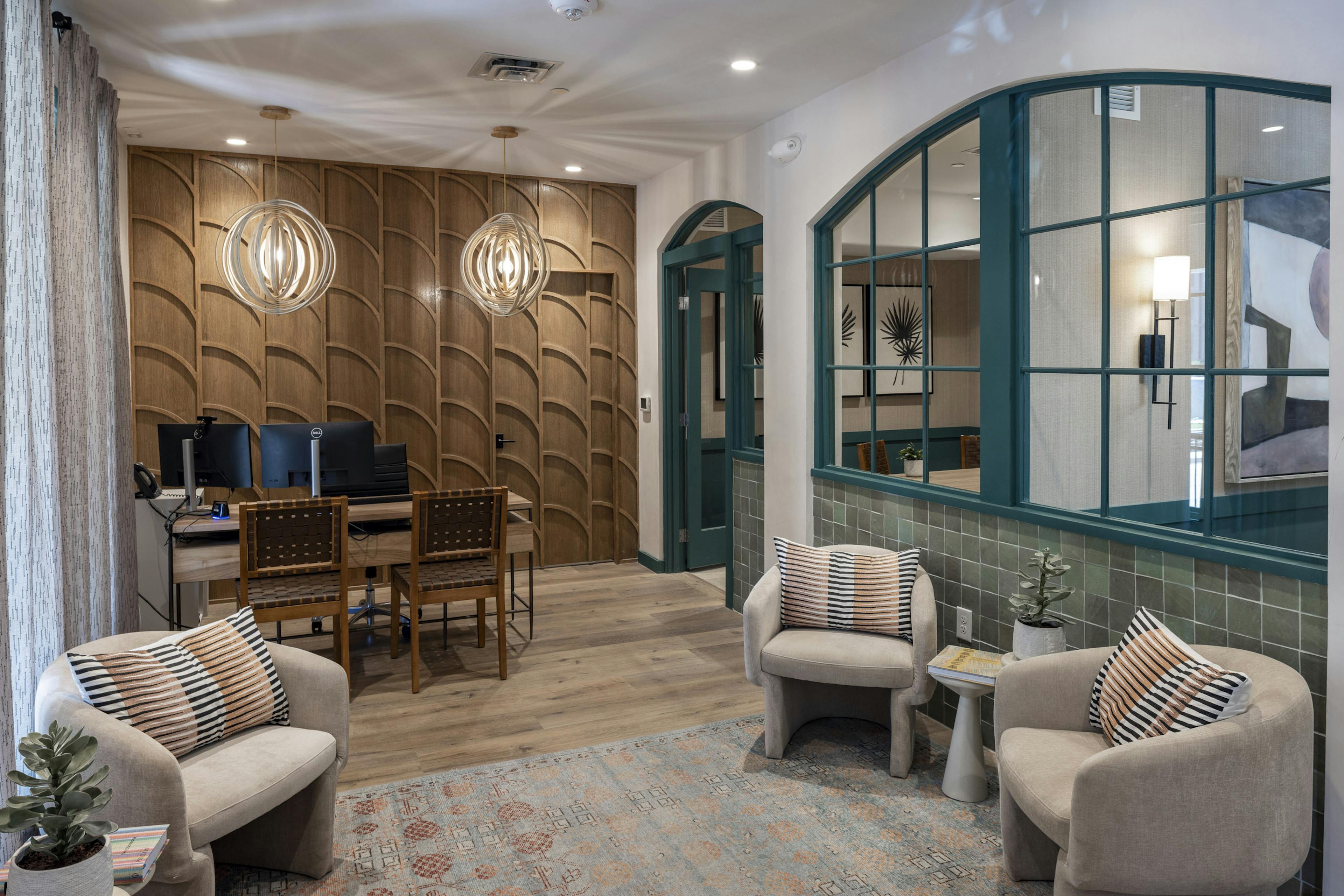 AMLI 300 apartments leasing office with wood textured wall and a desk with 2 chairs and upholstered chairs on an area rug