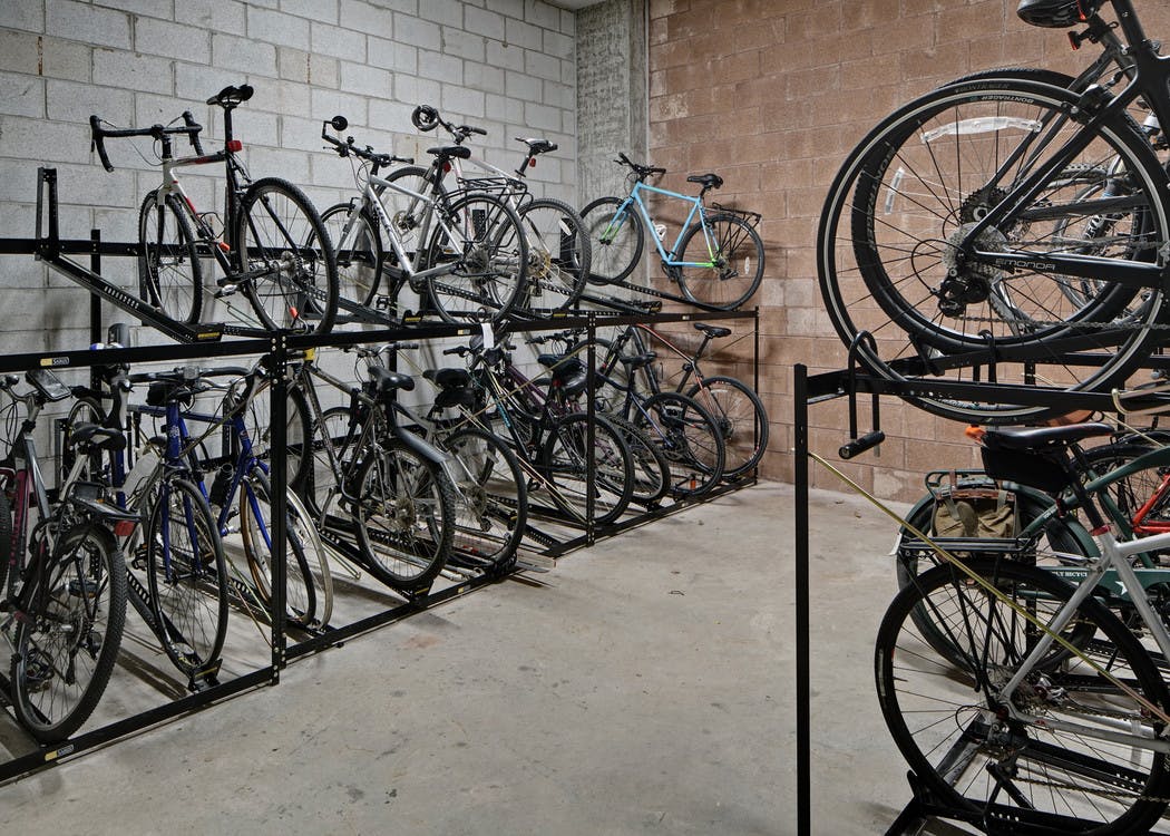 View of roughly twenty resident bicycles in a well lit storage area with cement flooring and white walls at AMLI Evanston