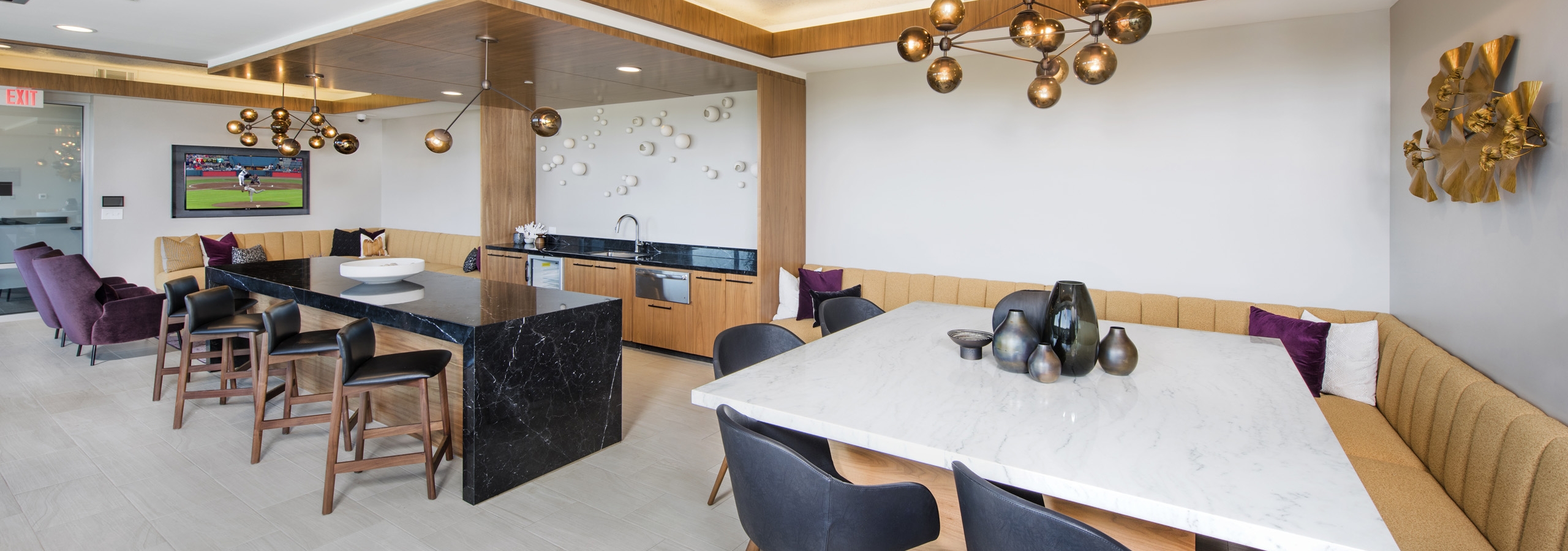 Interior of sky lounge deck at AMLI Decatur apartment building with serving kitchen and large TV with booth seating areas