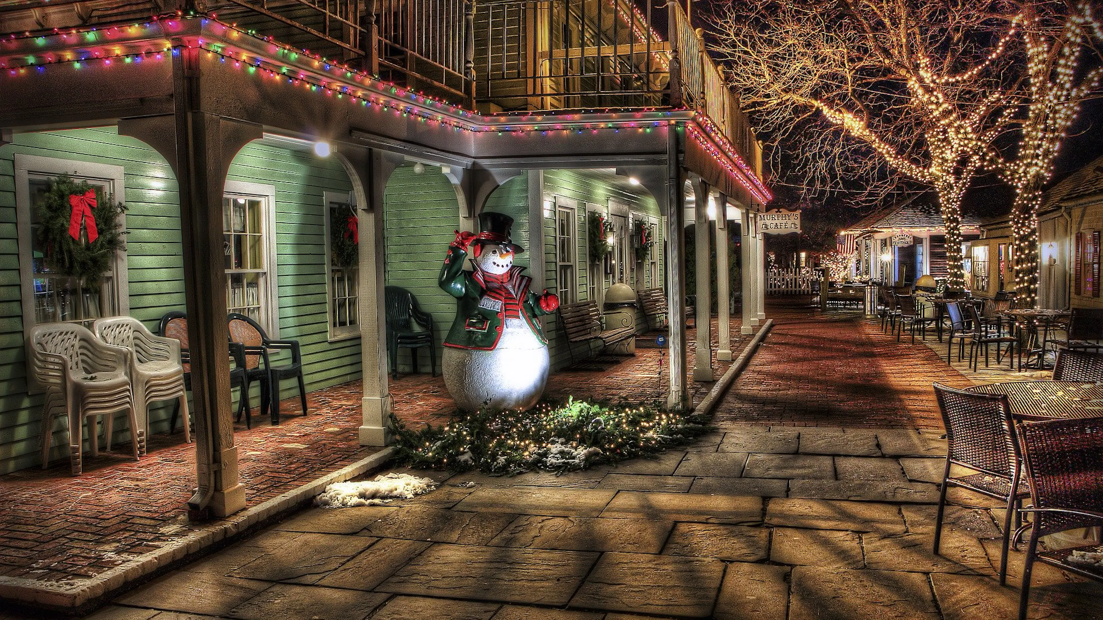 Snowman outside a quiet restaurant in the evening.