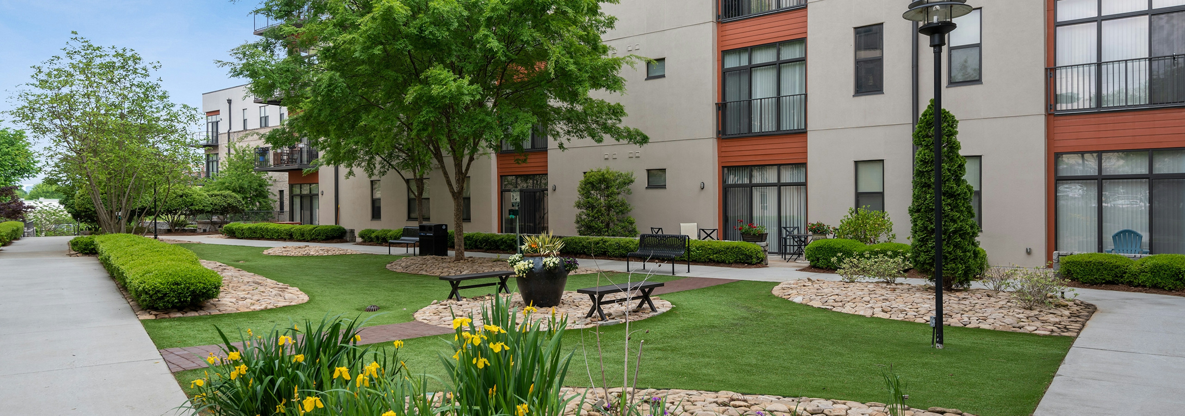 AMLI Old 4th Ward outside courtyard with luscious green grass and tulips with benches to sit on to breathe in fresh air