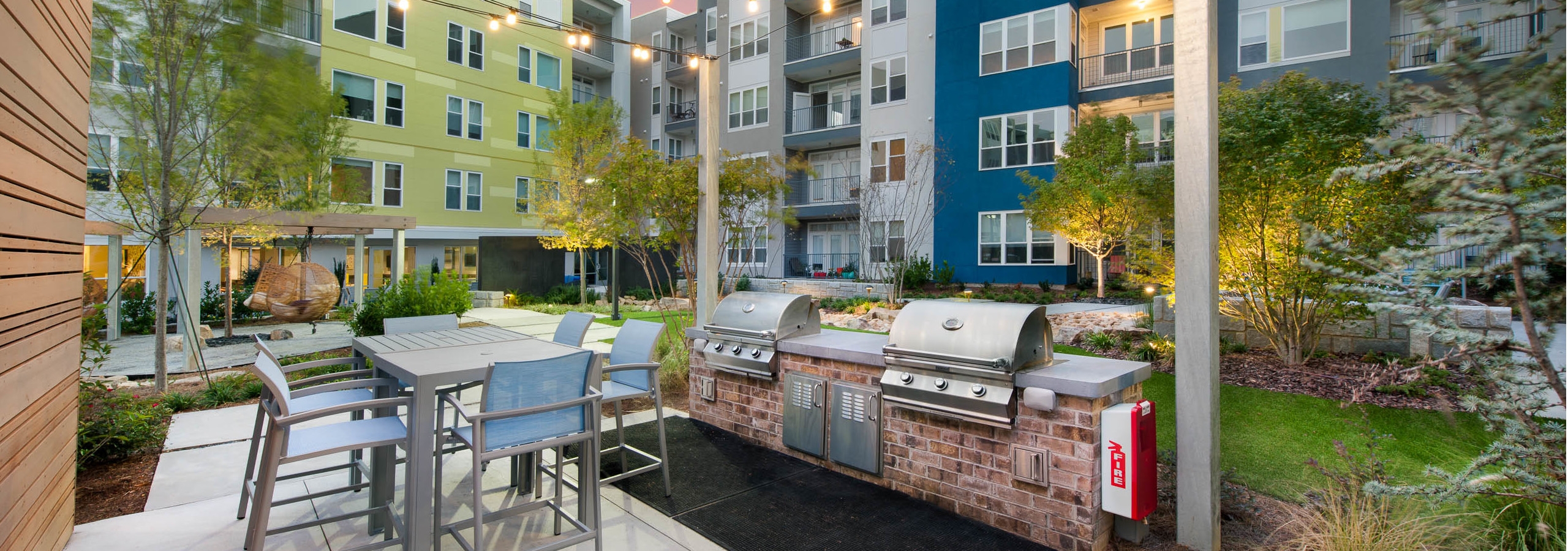 Outdoor grilling area at AMLI Piedmont Heights with stainless steel grill and counter space for food prep with high top table