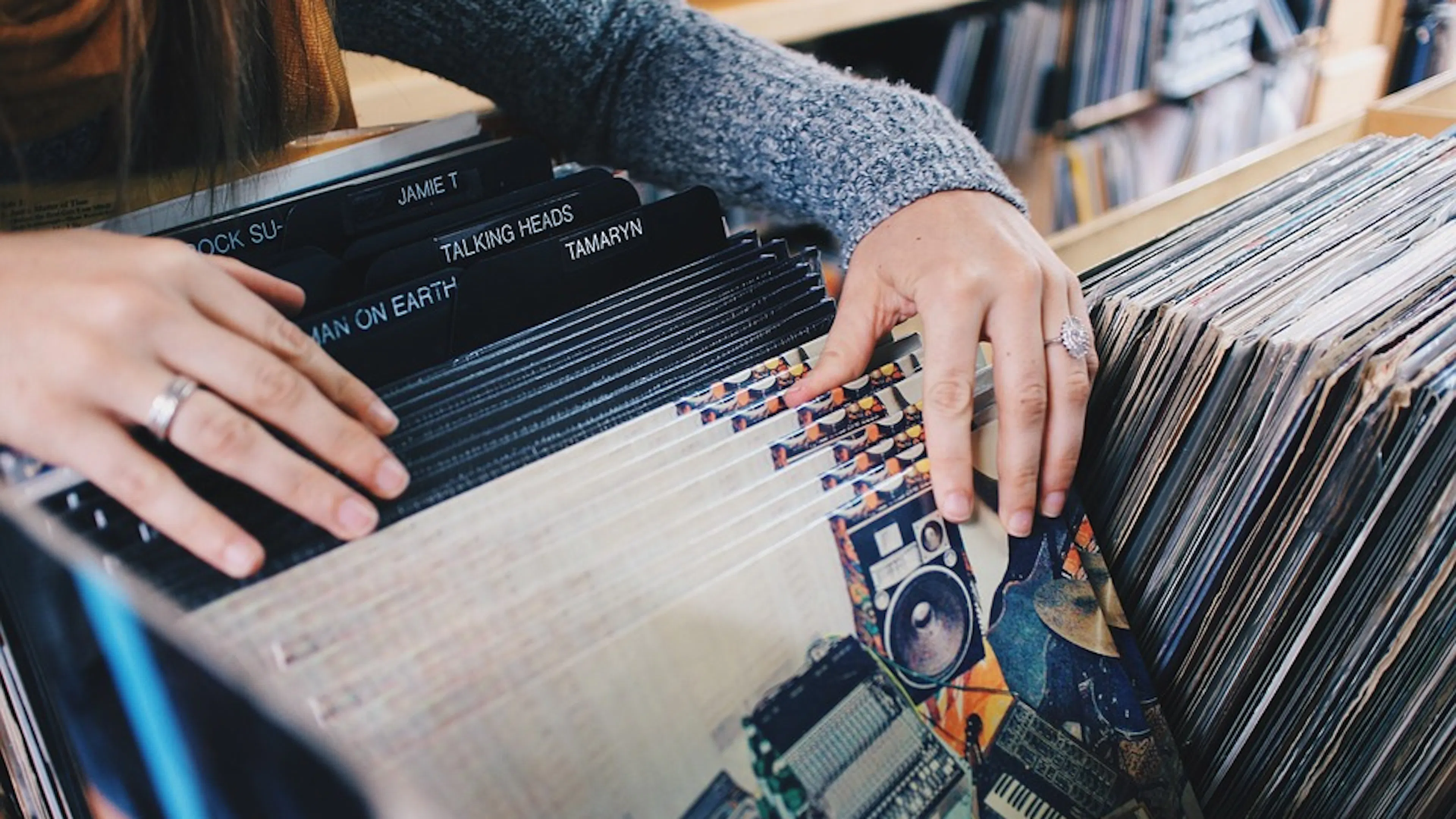 A person riffling through a large box of vinyl records