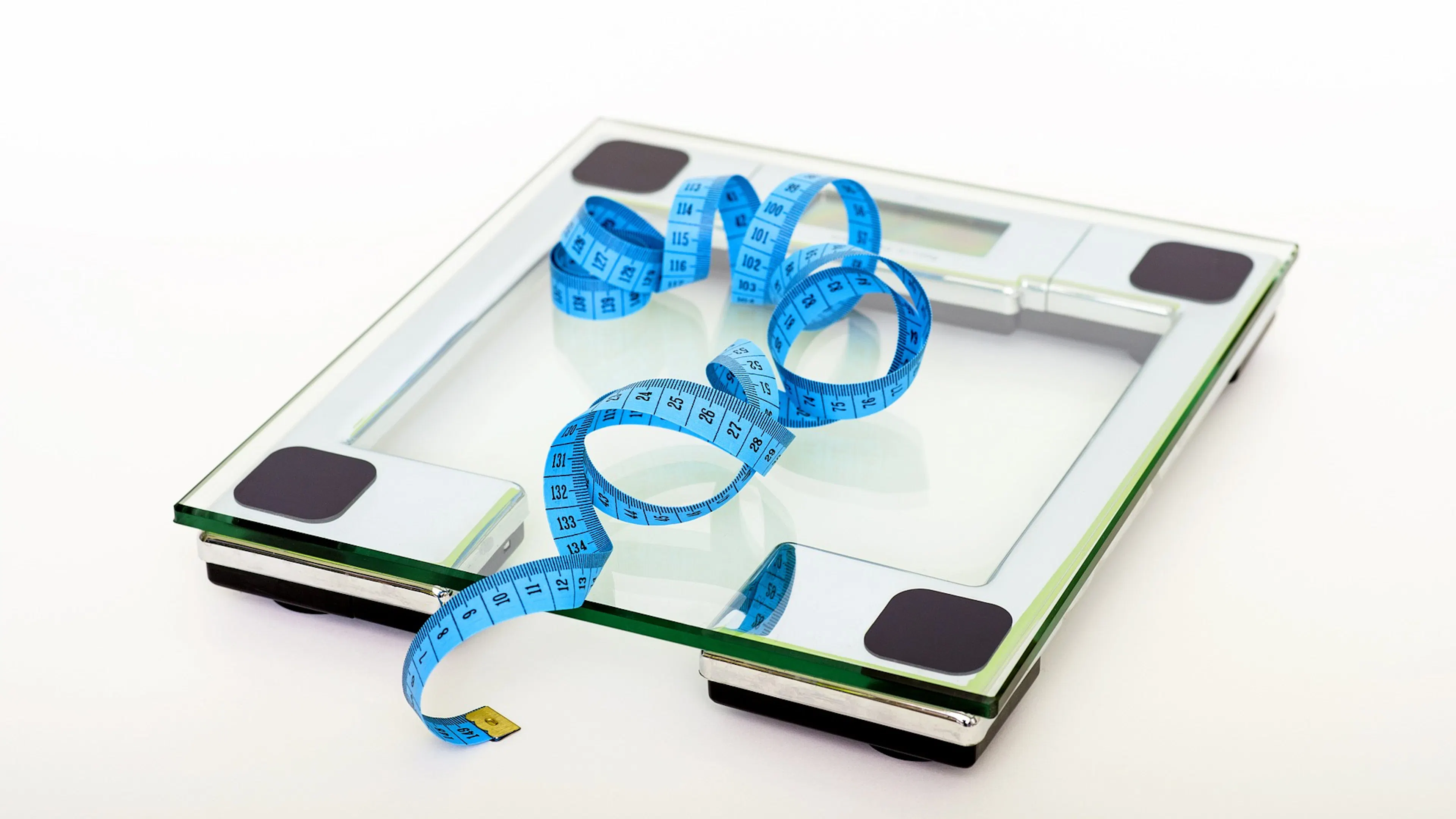 clear glass scale with blue measuring tape coiled on top
