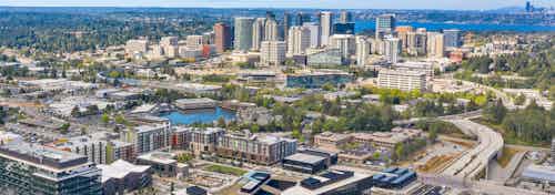 Aerial view of AMLI Spring District apartment building with surrounding Bellevue neighborhood and lake behind buildings