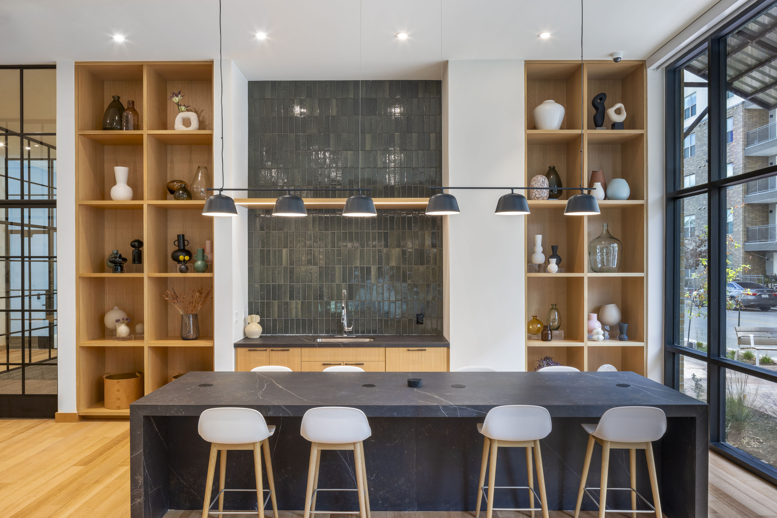 Coworking space at AMLI Branch Park apartments featuring a large quartz kitchen island flanked by two large wooden shelves
