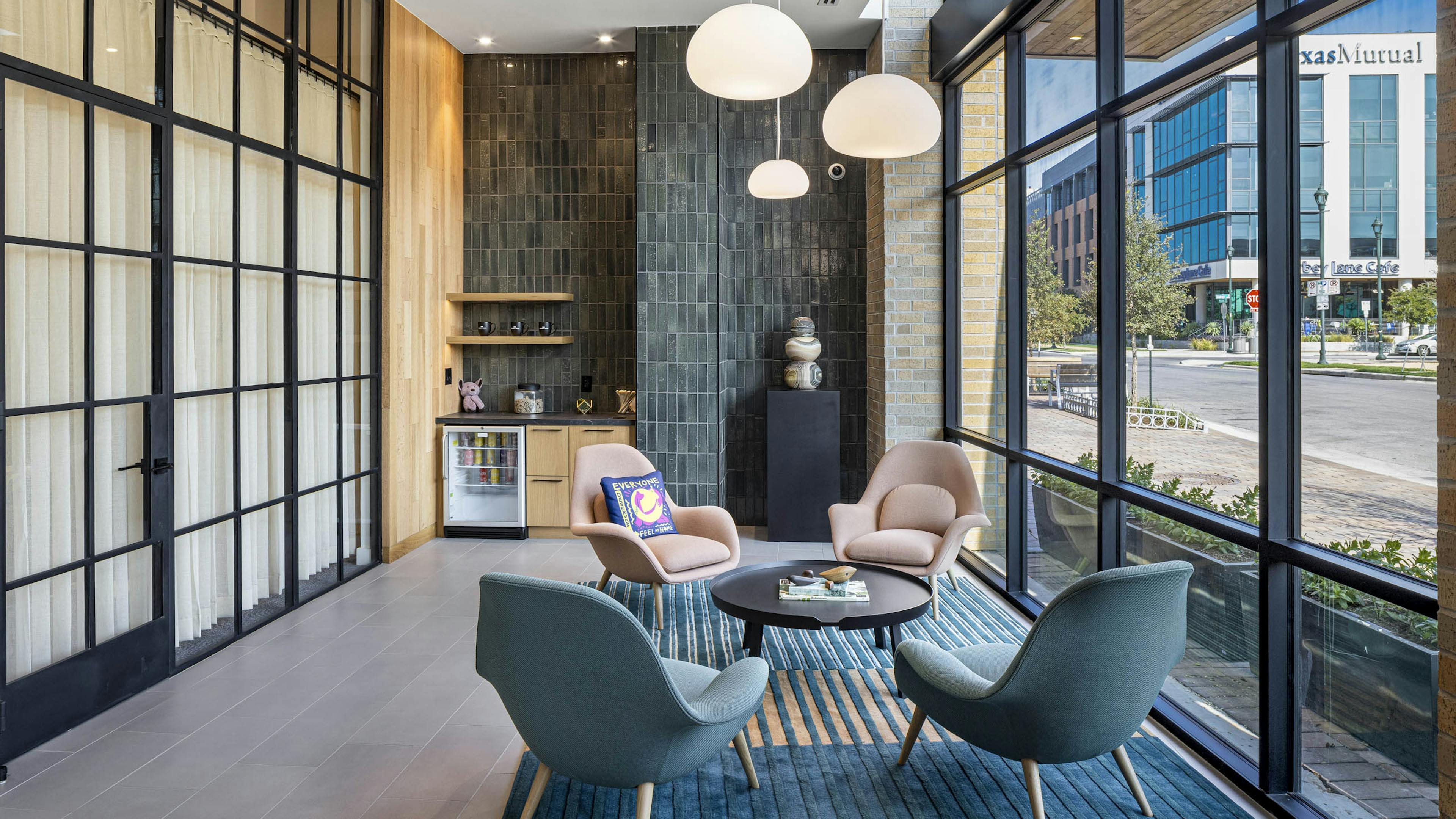 Lounge at AMLI Branch Park with curtained window wall and grey tile wall and seating area with window wall and view to exterior