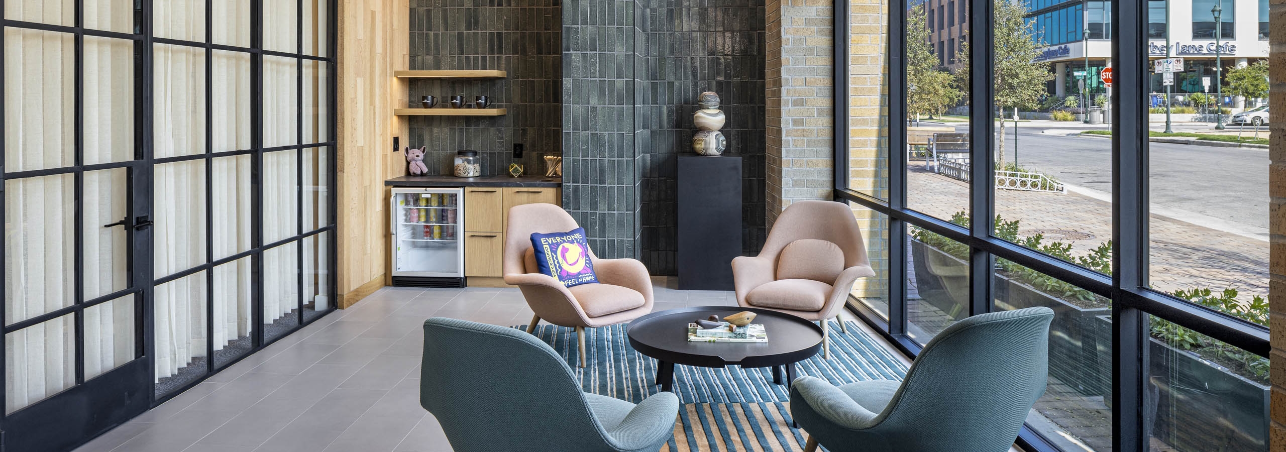 Leasing office at AMLI Branch Park with curtained window wall and grey tile wall and seating area with window wall and exterior view