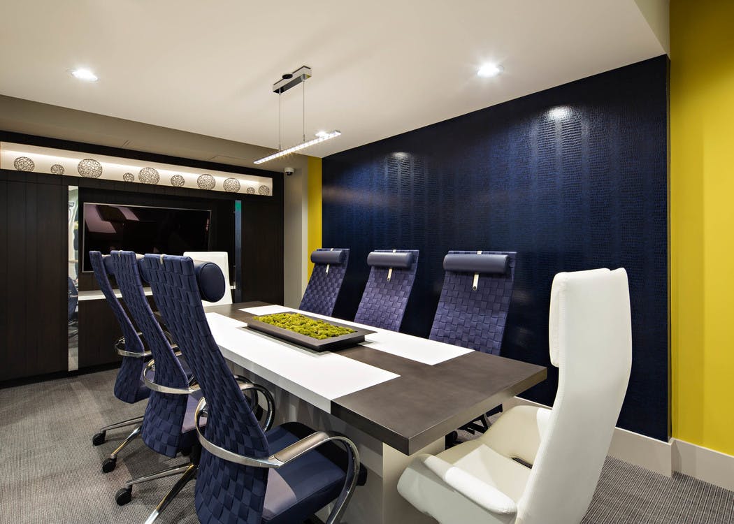 Interior view of the business center conference table at AMLI Lex on Orange apartments with big blue chairs and big screen TV