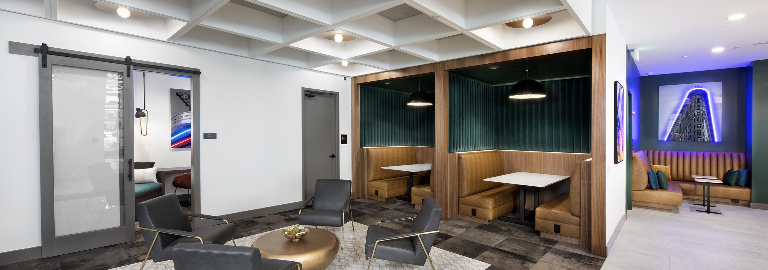 AMLI Flatiron clubhouse with coffered ceiling grey chairs and gold table with banquet seating and neon artwork