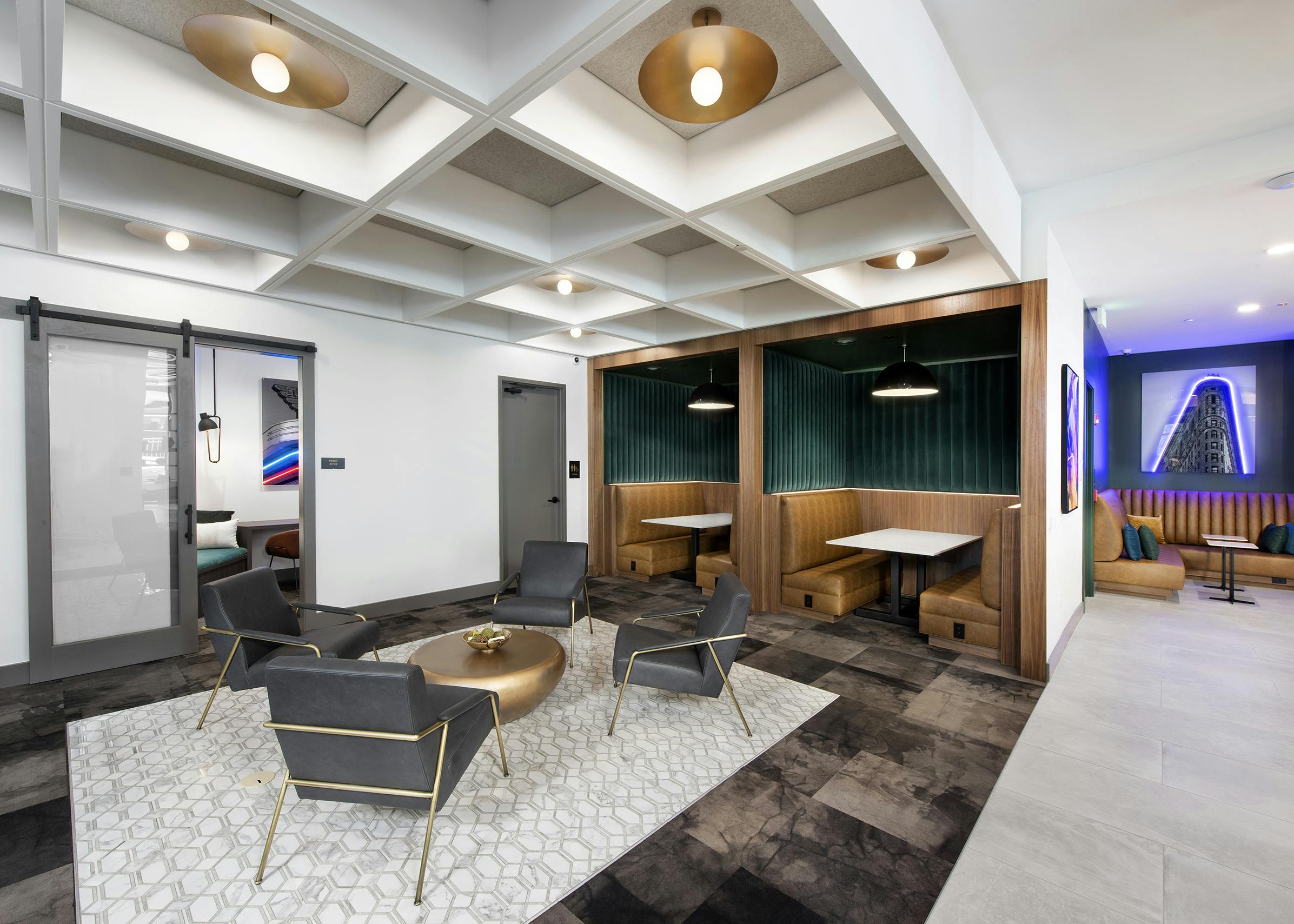 AMLI Flatiron clubhouse with coffered ceiling grey chairs and gold table with banquet seating and neon artwork