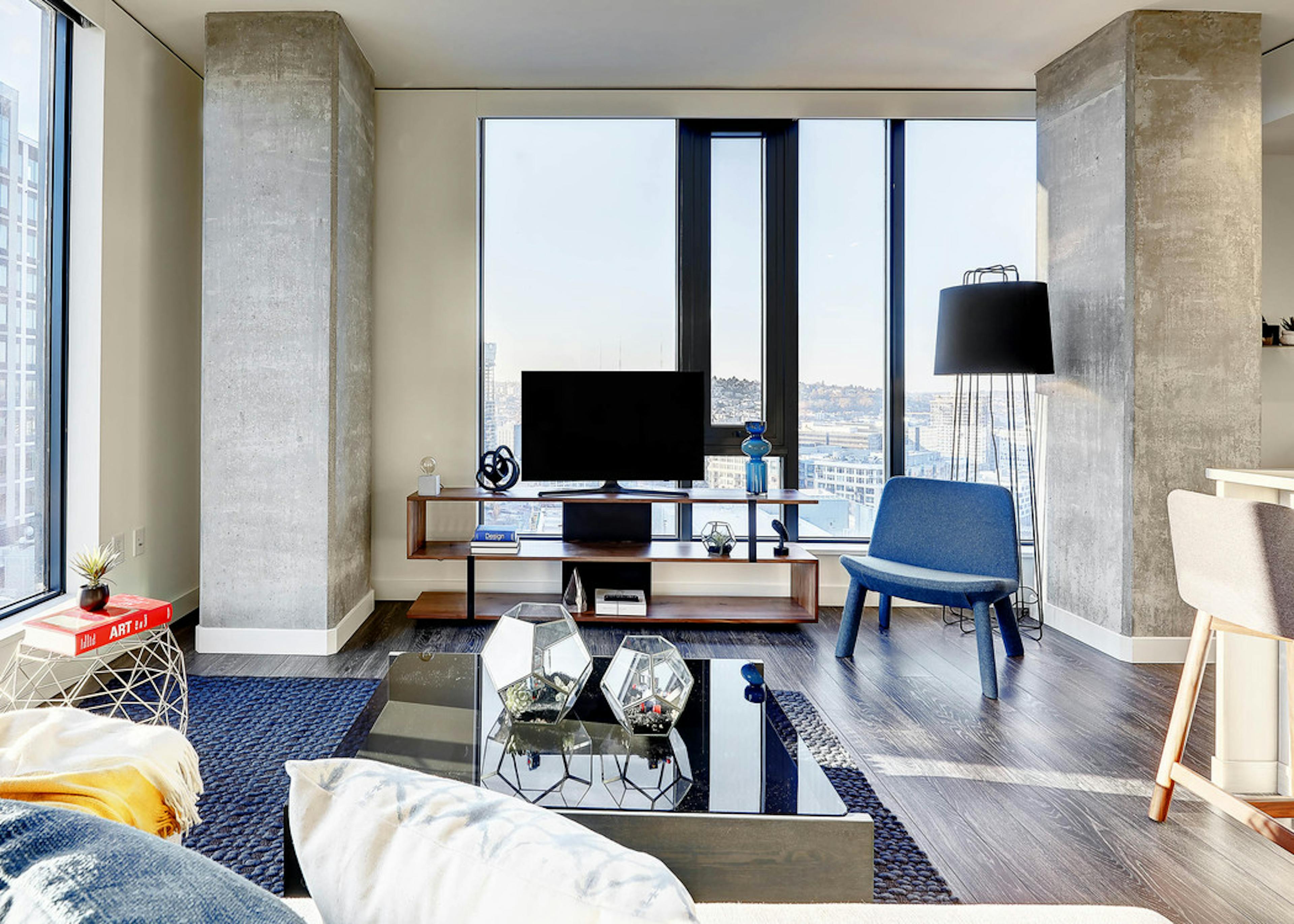 Interior view of apartment of AMLI Arc of living room and window and peek inside bedroom with open door  