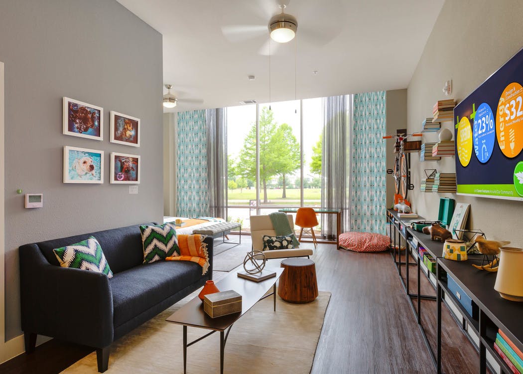 Close up of AMLI at Mueller living room with chevron throw pillows and curtains and grey walls with dark flooring