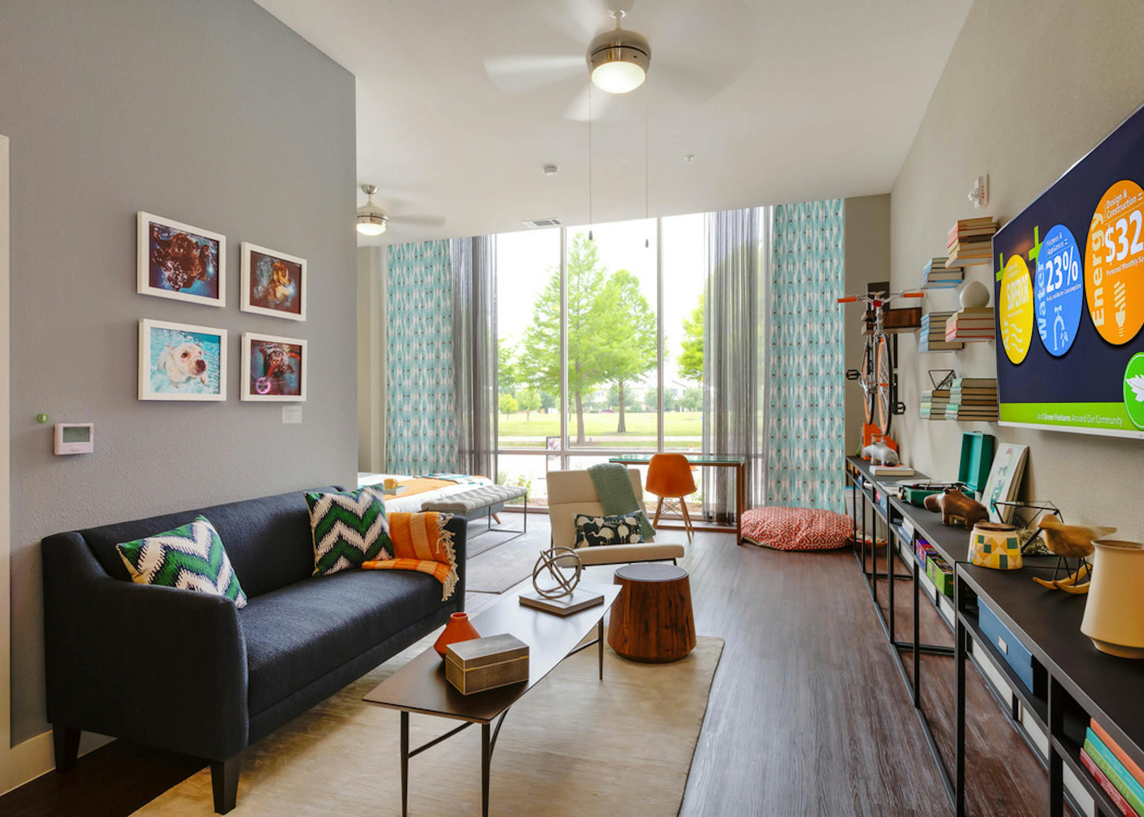 Close up of AMLI at Mueller living room with chevron throw pillows and curtains and grey walls with dark flooring