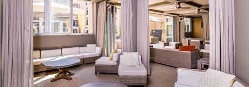 Daytime interior of poolside clubhouse with stylish lounge seating and room divider curtains at AMLI RidgeGate apartments