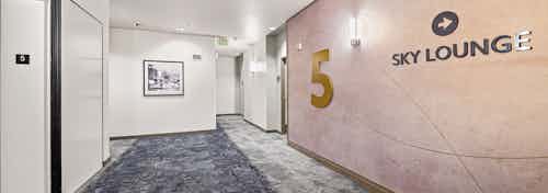 Sky lounge and 5 on tan wall in hallway with blue and grey carpet and view of the elevator at AMLI Bellevue Park apartments