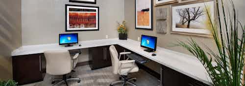 Interior of business center at AMLI Doral apartments with computer stations, desk chairs and artwork on the wall