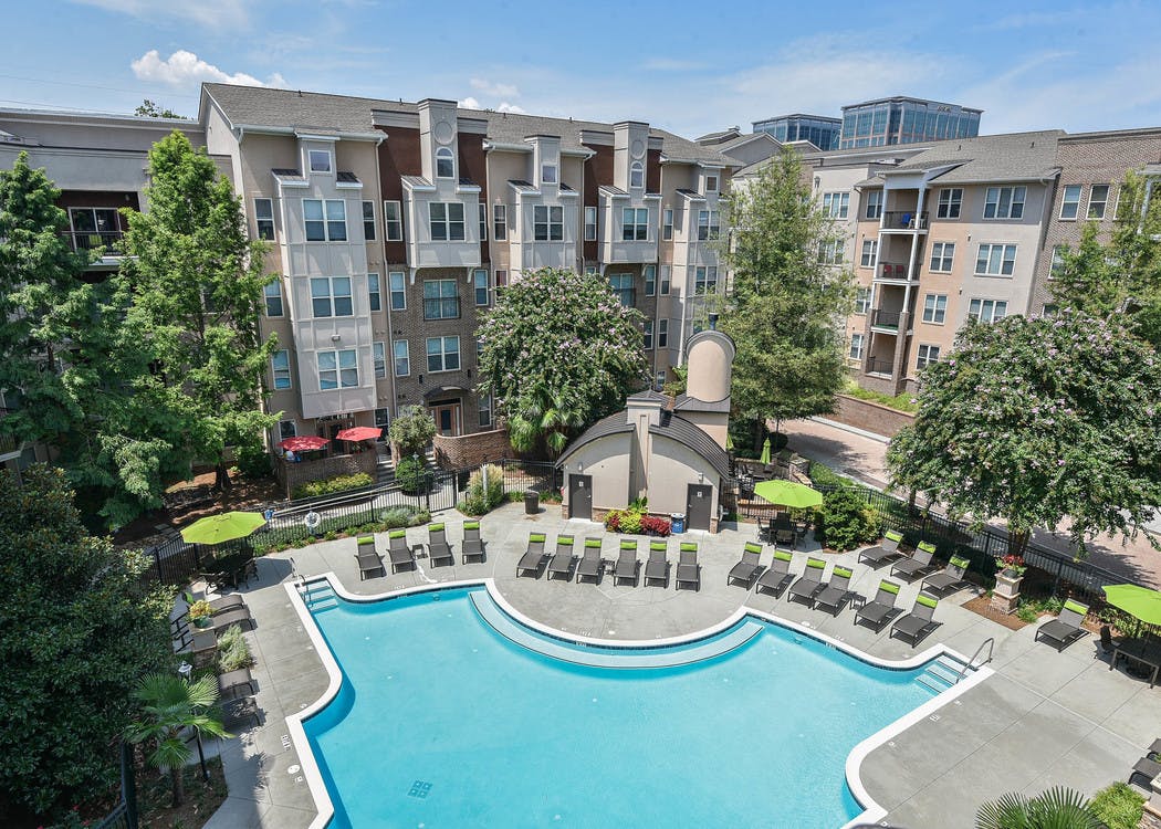 Ariel view of AMLI Lindbergh apartment community with a large pool and surrounding lounge chairs in the daytime