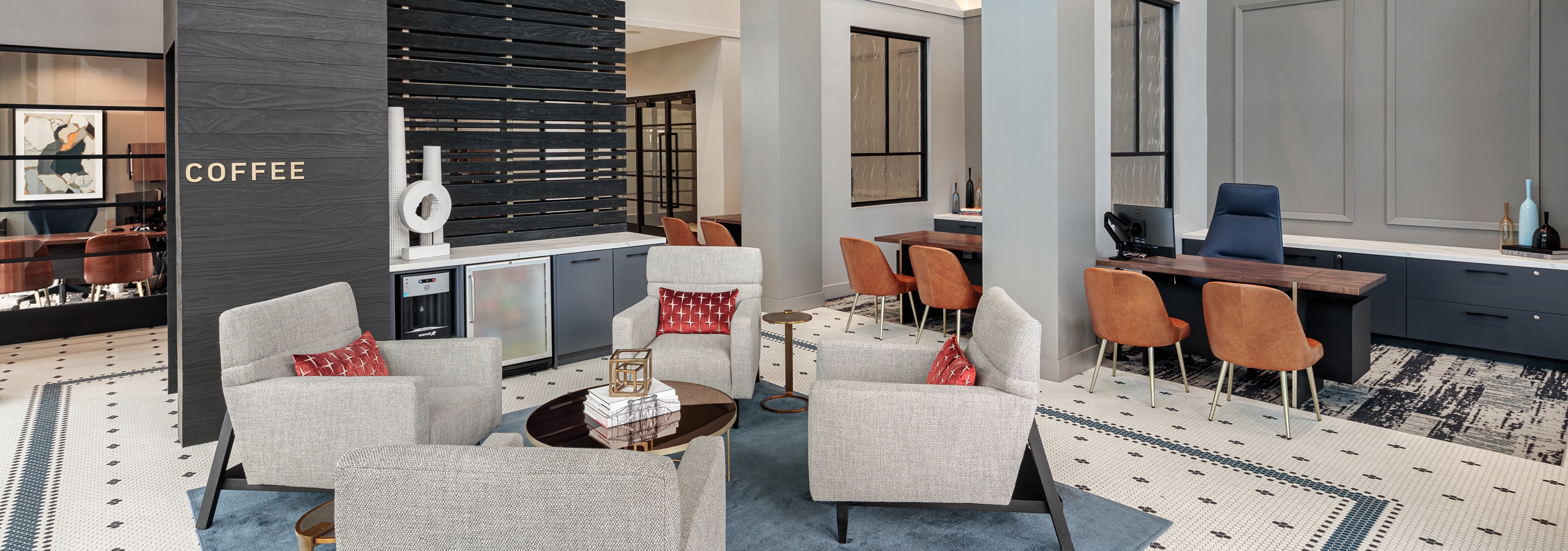 AMLI Addison leasing office with white patterned flooring and four white sofa chairs with leasing desks in background