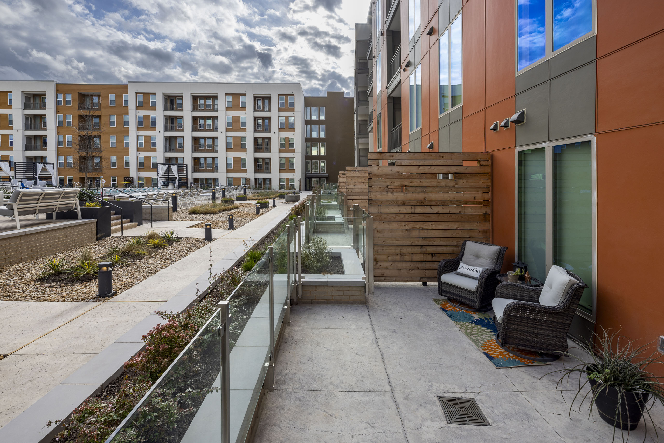 AMLI Branch Park oversized poolside courtyard apartment patio with two lounge chairs and potted landscaping throughout