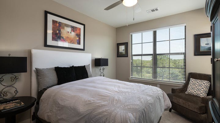 A daytime interior view of AMLI Covered Bridge bedroom with a view of the surrounding Austin Hill Country