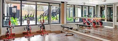 Interior of the Yoga Room at AMLI Wallingford with spin bikes free weights ballet bar and fitness on demand