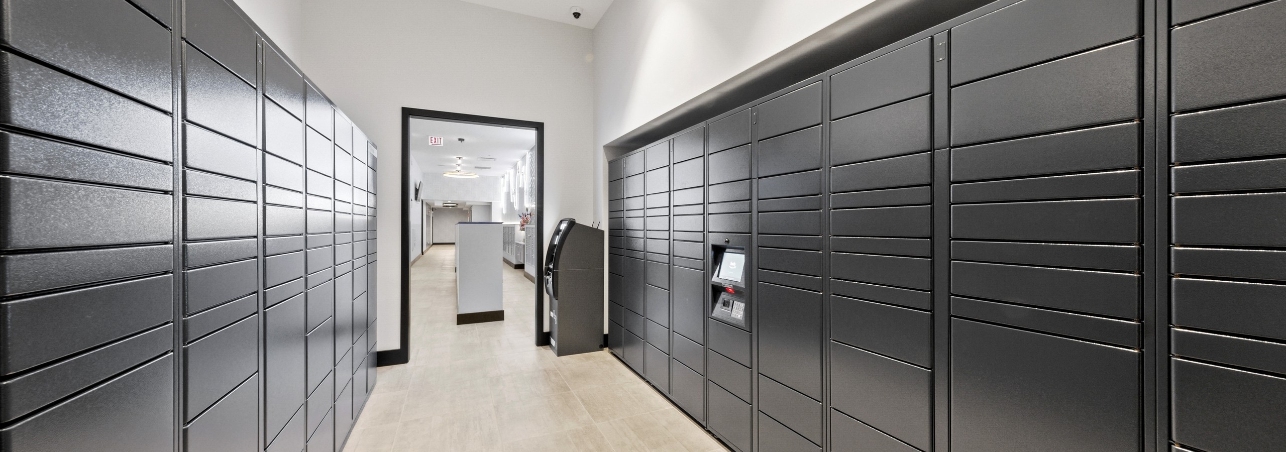 Interior view of mailroom at AMLI 808 featuring stacked grey mailboxes surrounded by light walls and sleek flooring