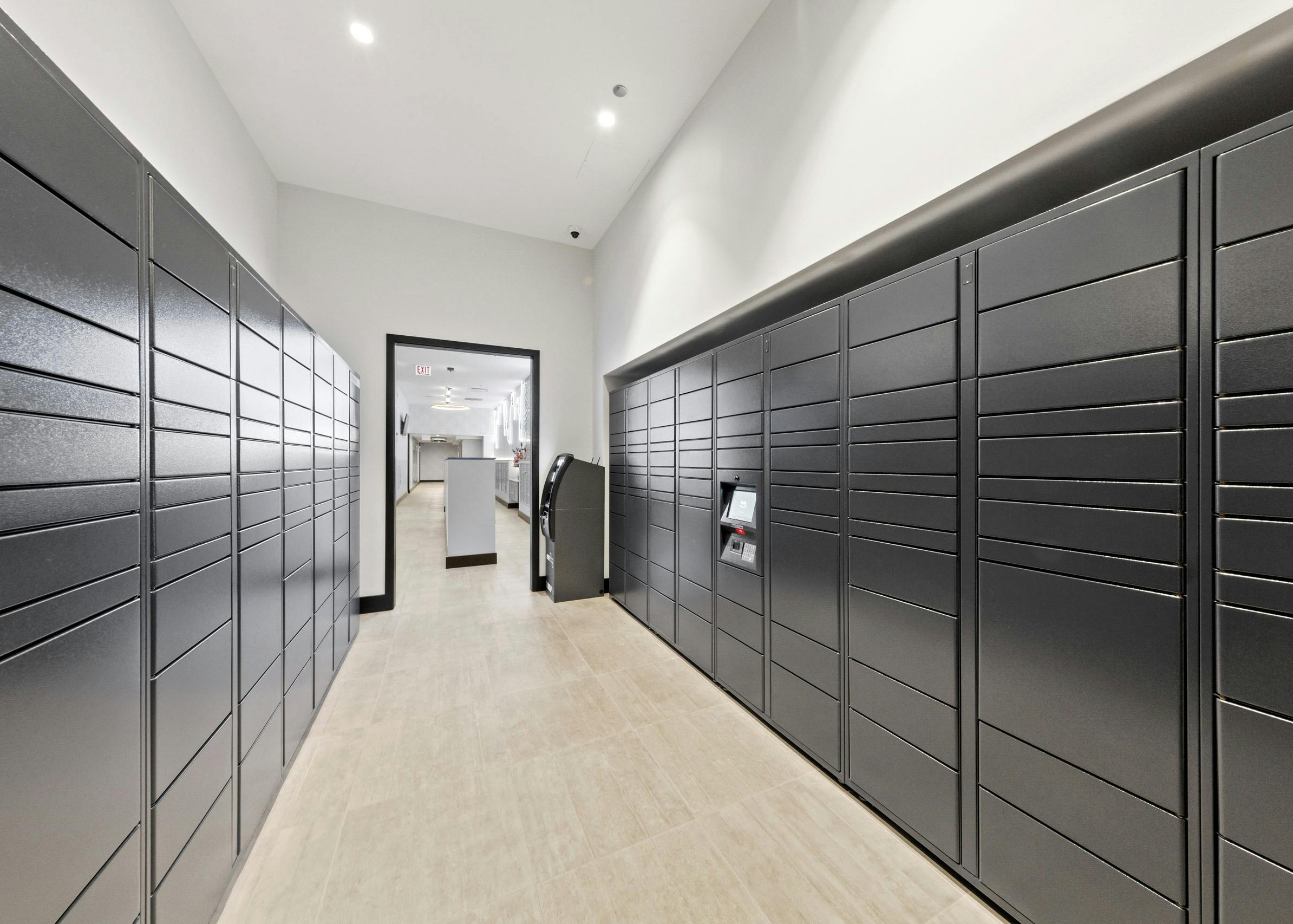 Interior view of mailroom at AMLI 808 featuring stacked grey mailboxes surrounded by light walls and sleek flooring