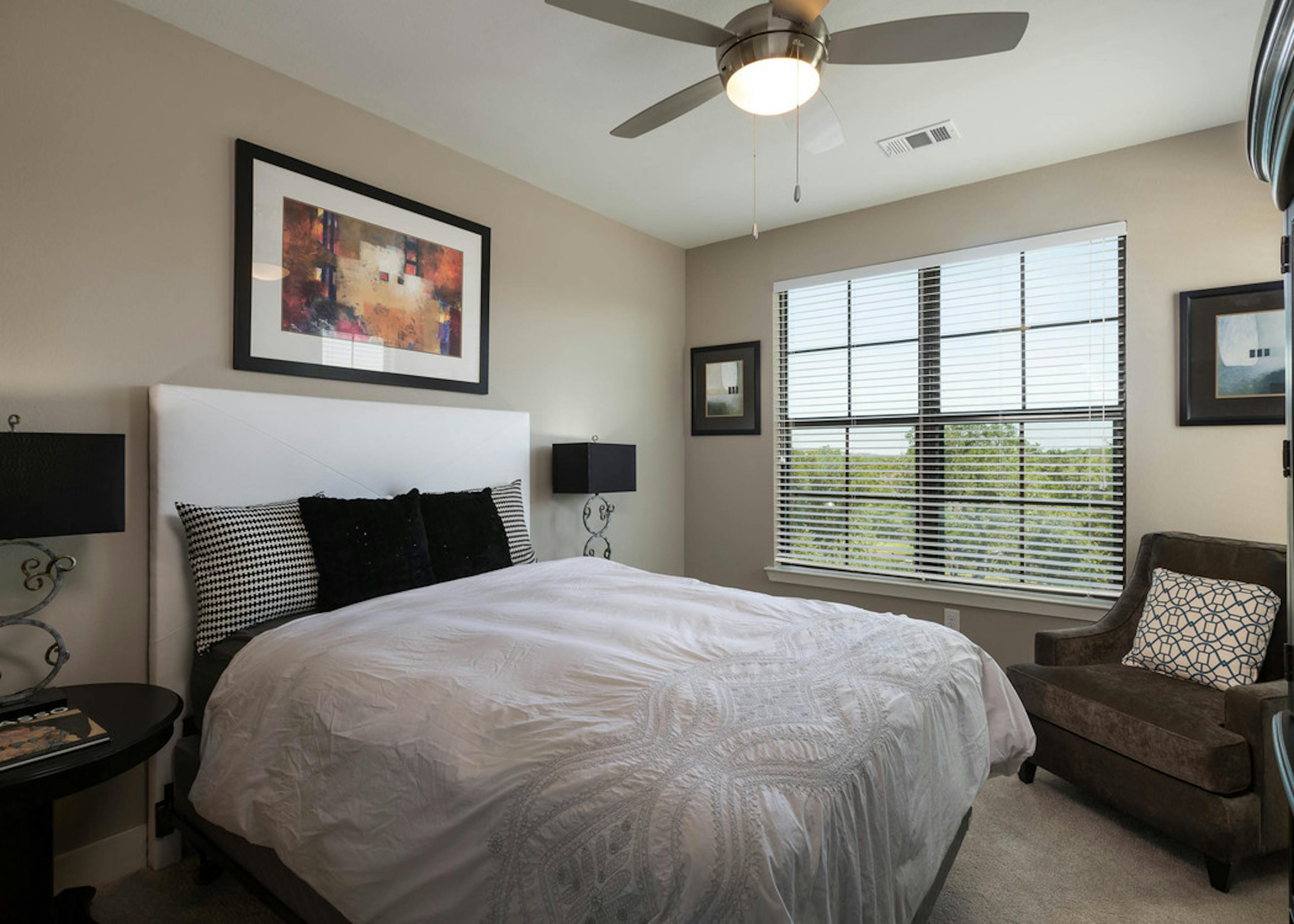 A daytime interior view of AMLI Covered Bridge bedroom with a view of the surrounding Austin Hill Country