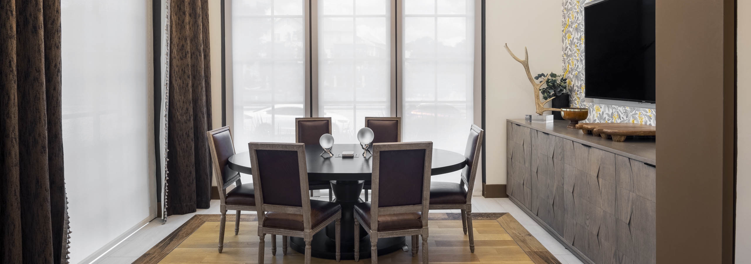 Conference Room at AMLI Lakeline apartments with vaulted ceilings and a wooden oval table surrounded by brown chairs