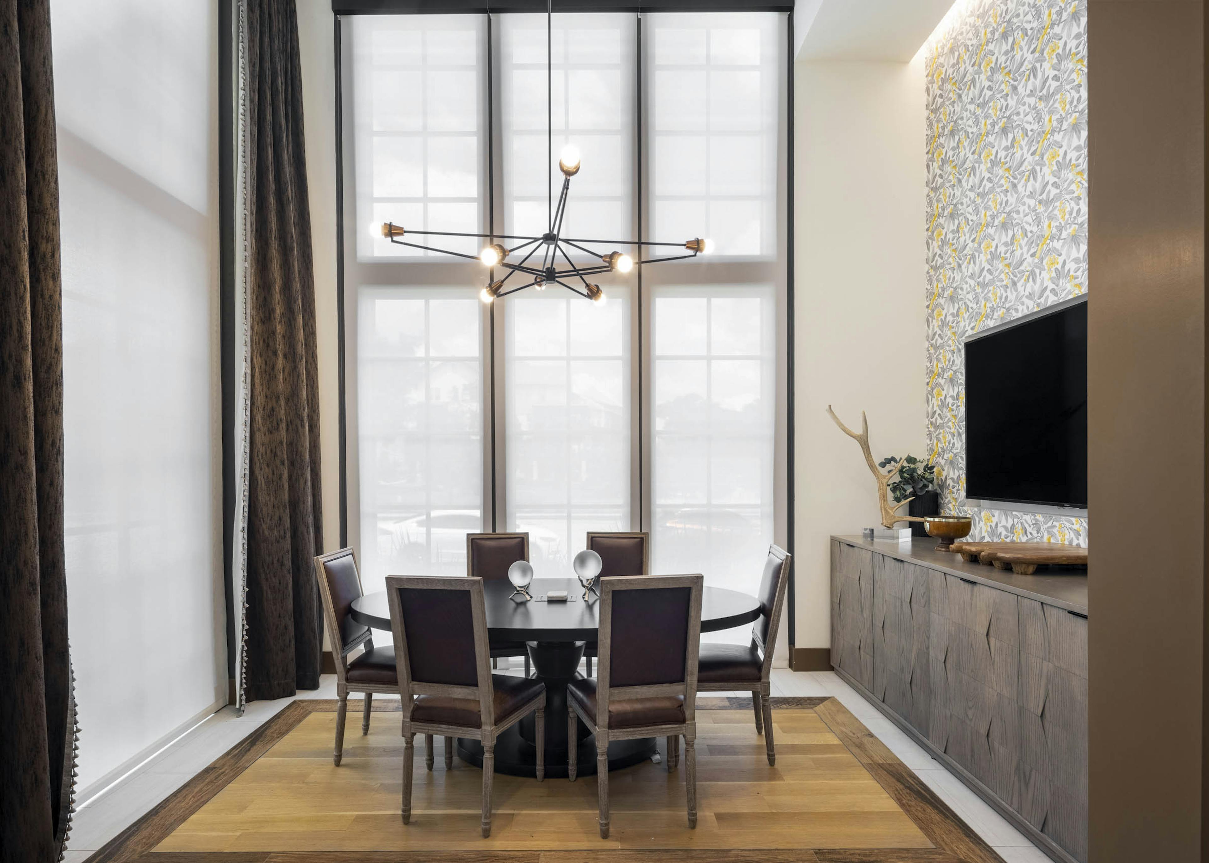 Conference Room at AMLI Lakeline apartments with vaulted ceilings and a wooden oval table surrounded by brown chairs