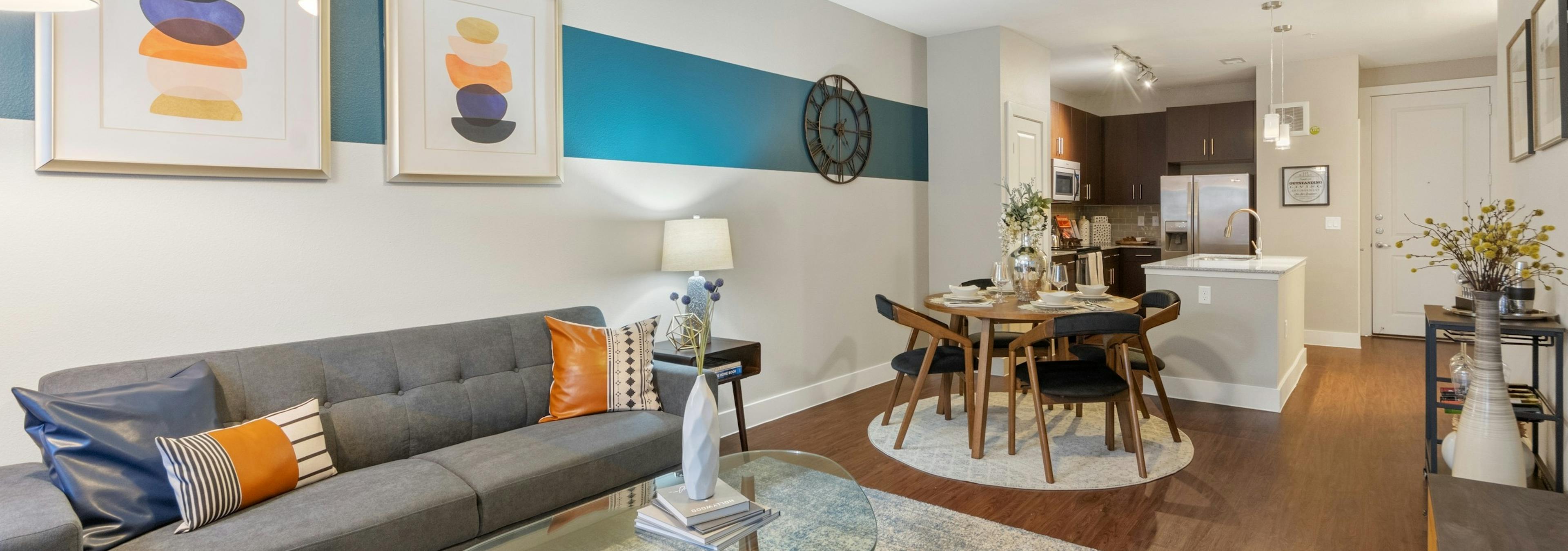 AMLI Riverfront Park apartment living room with colorful decor accents and view of connecting kitchen in background