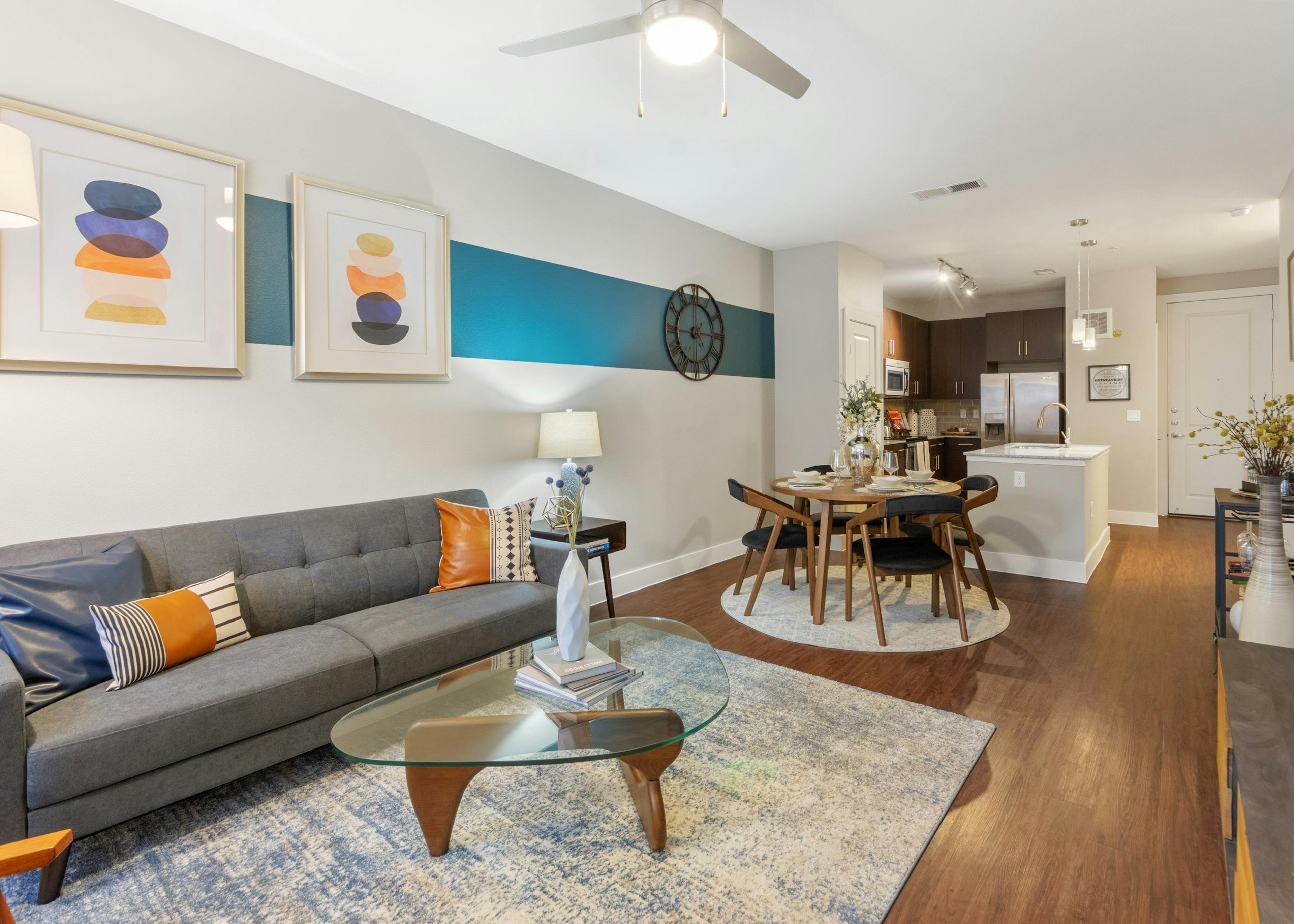 AMLI Riverfront Park apartment living room with colorful decor accents and view of connecting kitchen in background