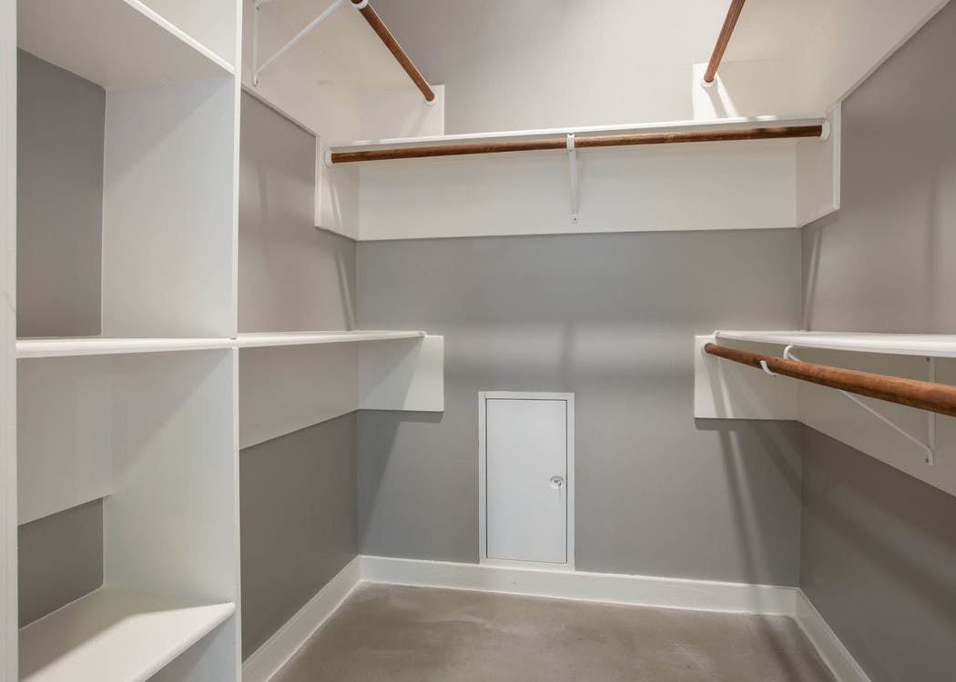 Interior view of walk in closet at AMLI Downtown with built in shelving of varying heights and space to hang clothing