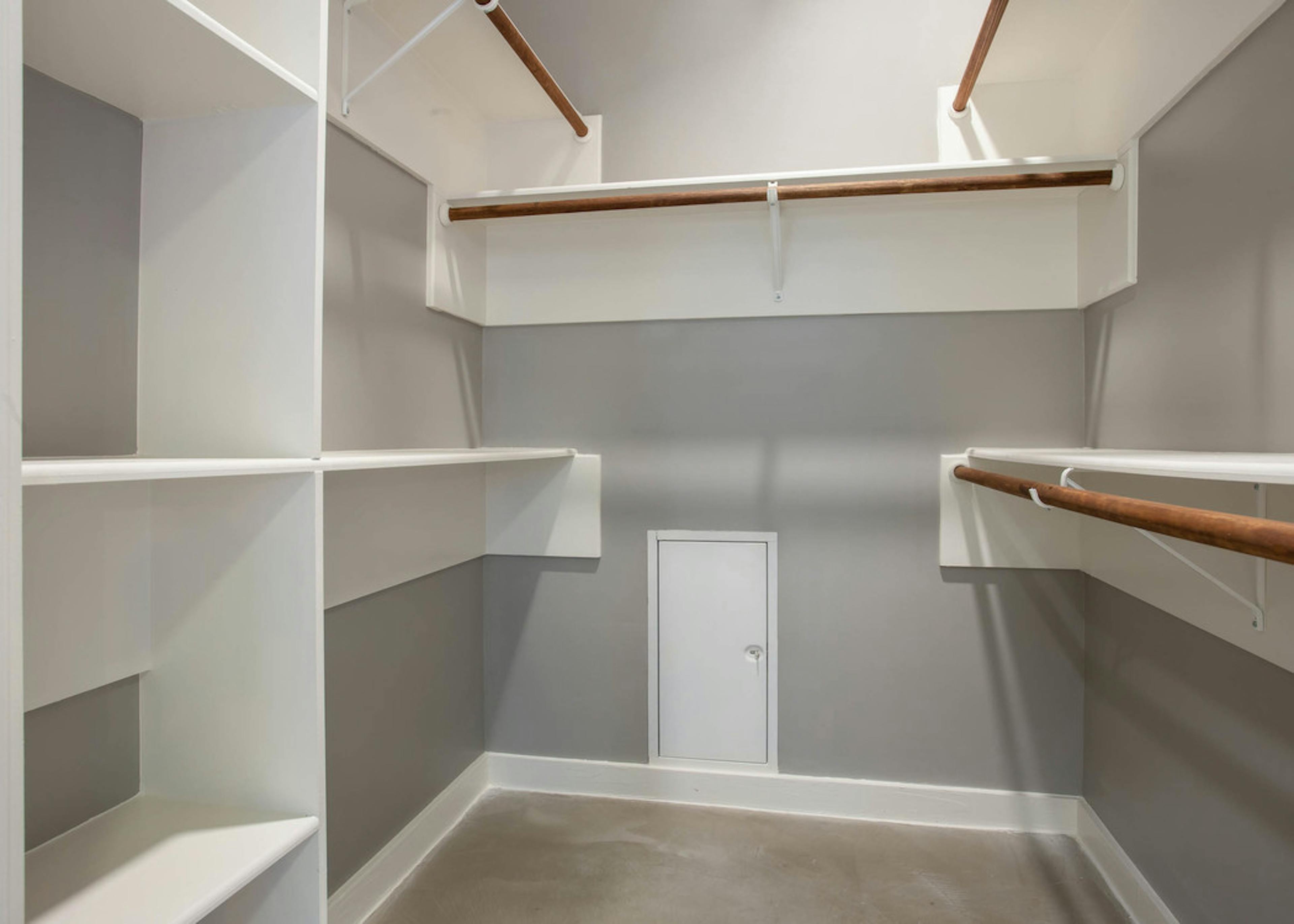 Interior view of walk in closet at AMLI Downtown with built in shelving of varying heights and space to hang clothing