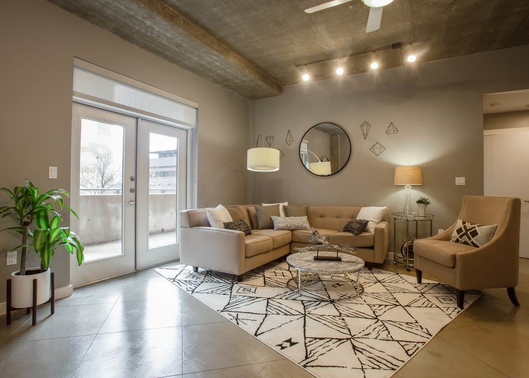 Interior of AMLI Downtown living room with neutral colored seating in front of balcony doors with bright daytime view