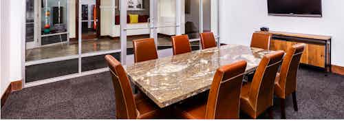 Interior view of a conference room at AMLI Park Avenue apartments with a granite table with padded chairs and a television