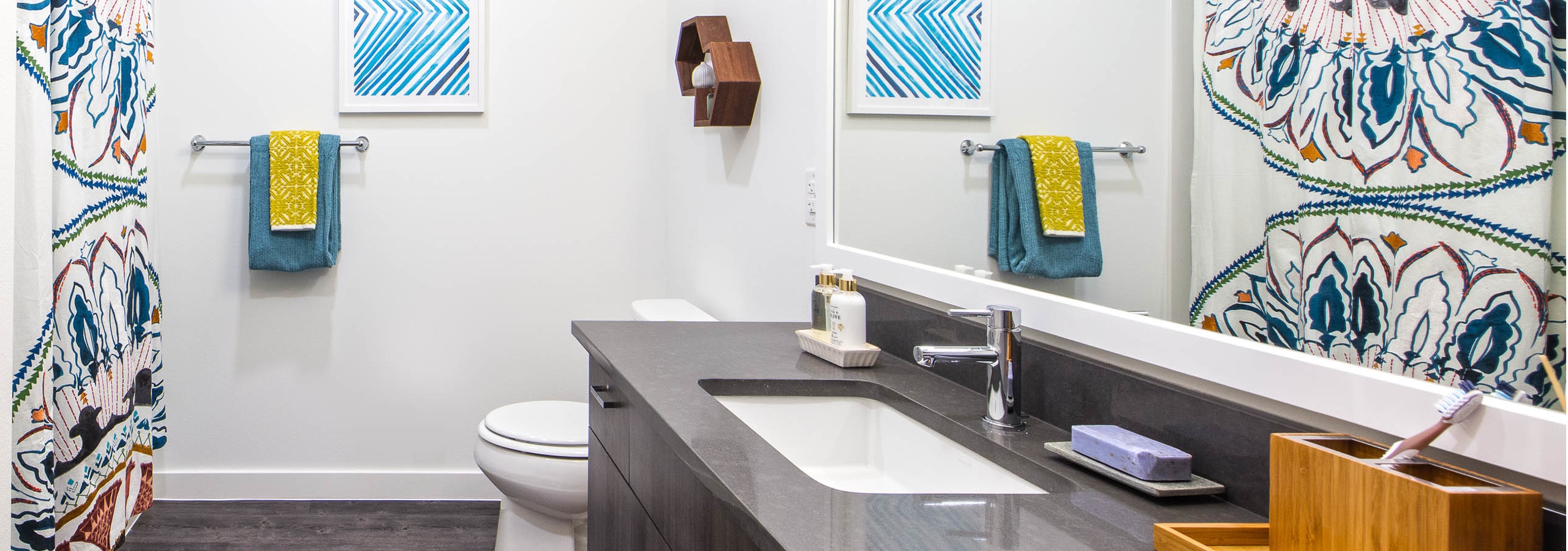 AMLI Wallingford apartment bathroom with dark quartz counter tops colorful towels and shower curtain