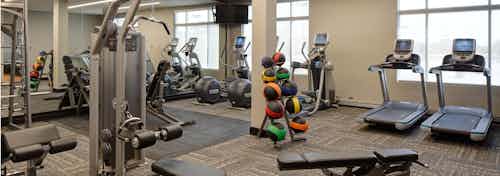 Fitness center at AMLI Deerfield with various cardio and weight machines including treadmills and elliptical machines