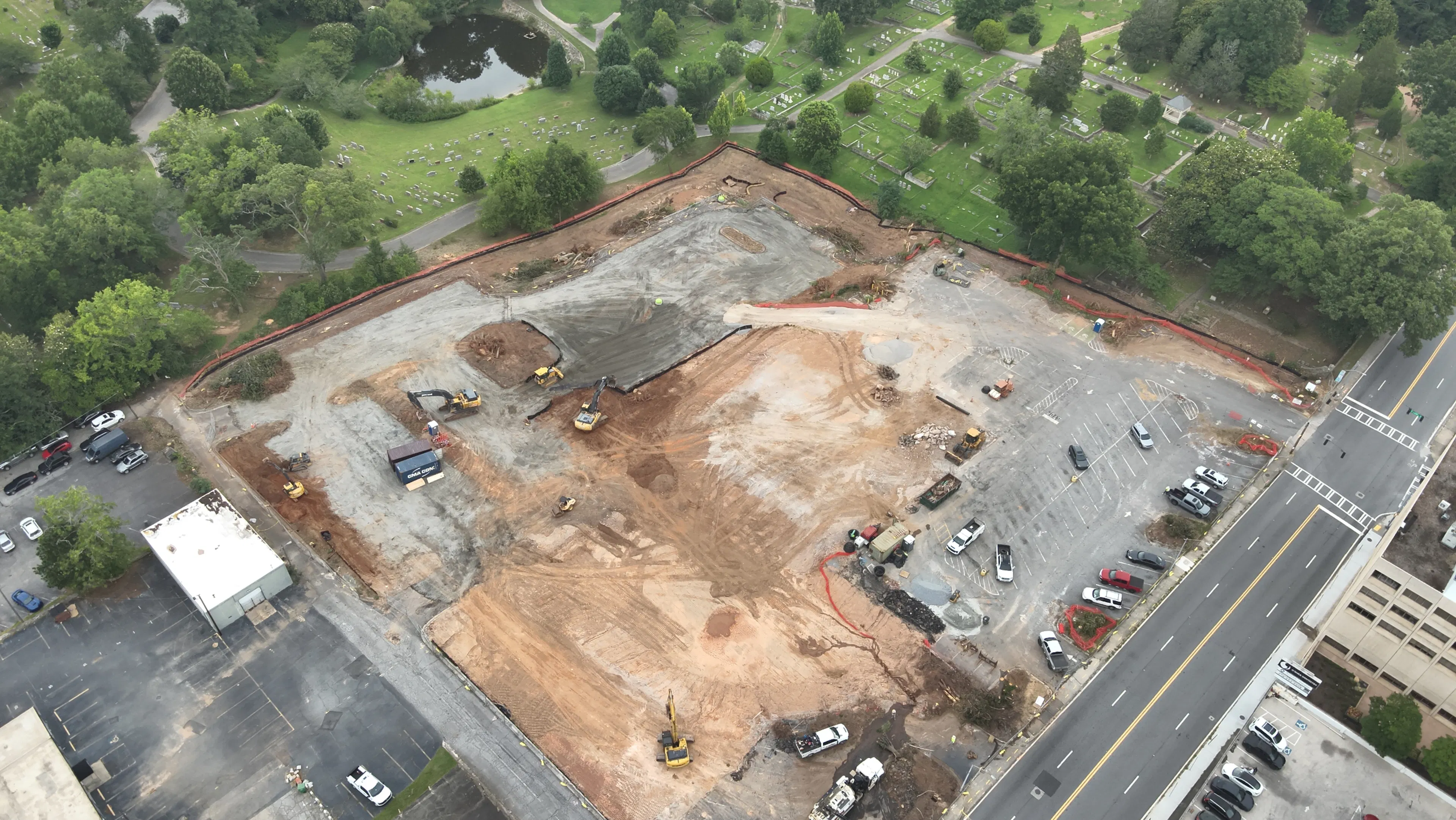 Aerial view of AMLI Market Square construction site and land grading progress showing active excavators and nearby green space.